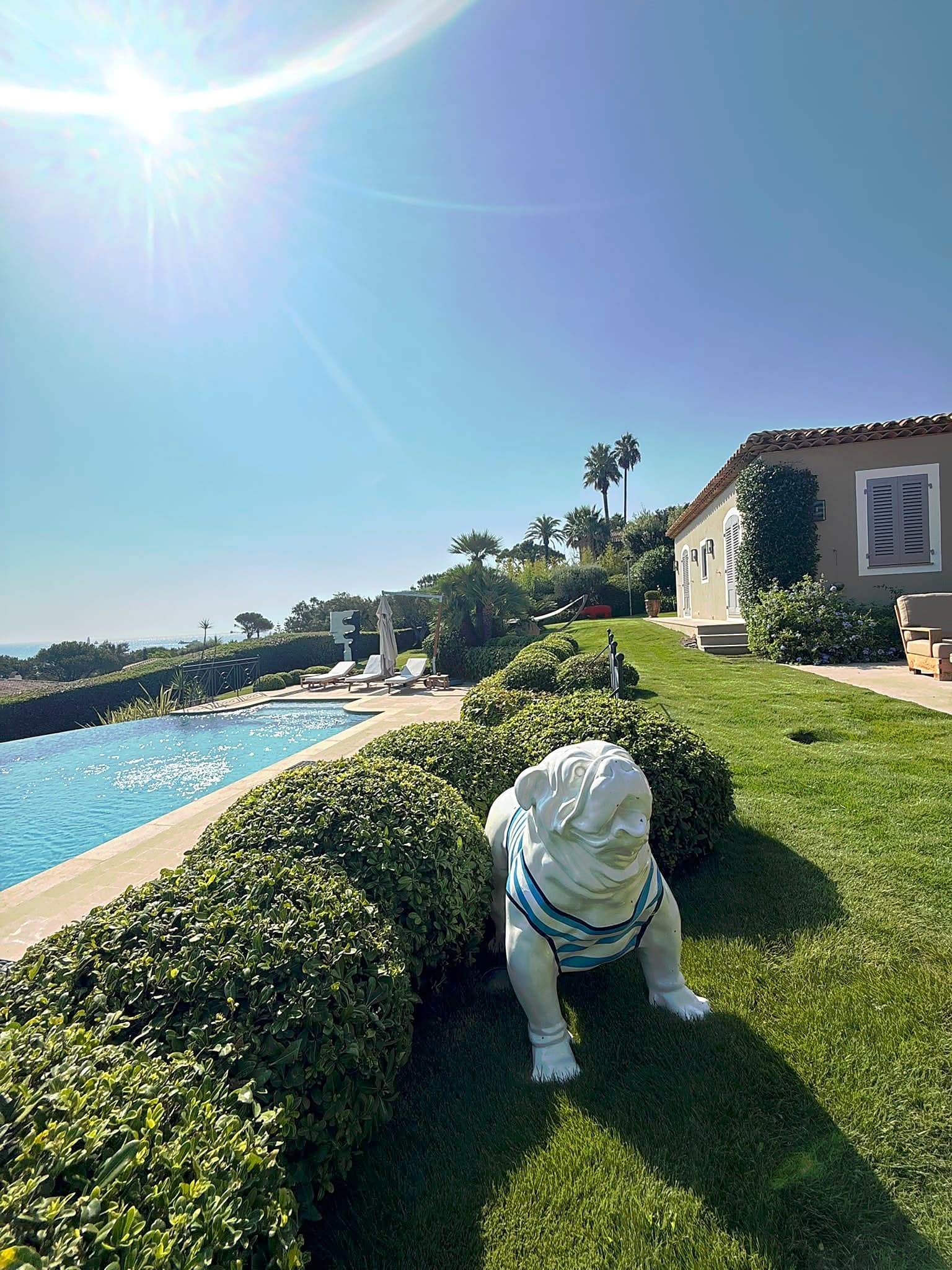 Villa avec piscine et vue sur la mer, pelouse tondue et haies taillées en boule